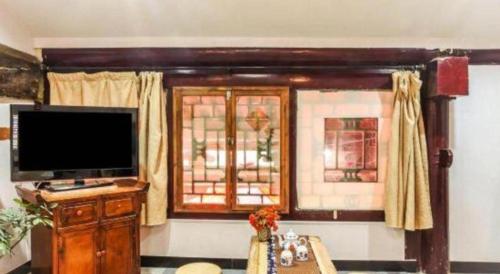 a living room with a television and a window at Pingyao Yufengheng Hotel in Pingyao