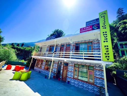 a building with a sign on the side of it at Hotel Mountain View Hill-Top Heaven Resort Cafe And Restuarant in Vashisht
