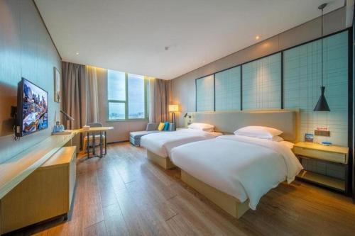 Postel nebo postele na pokoji v ubytování Echarm Hotel Yangjiang Baili Plaza