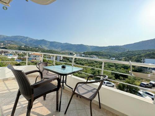a table and chairs on a balcony with a view at Villa Bodini Himare in Himare