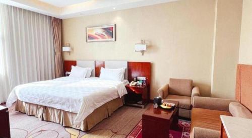 a hotel room with a bed and a couch at Qingdao Blue Horizon Hotel Licang in Qingdao