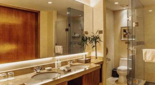 a bathroom with two sinks and a shower at Qingdao Blue Horizon Hotel Licang in Qingdao