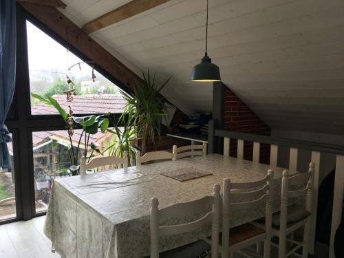 une table et des chaises dans une pièce avec une fenêtre dans l'établissement Maison Chez Loulou, à Léon