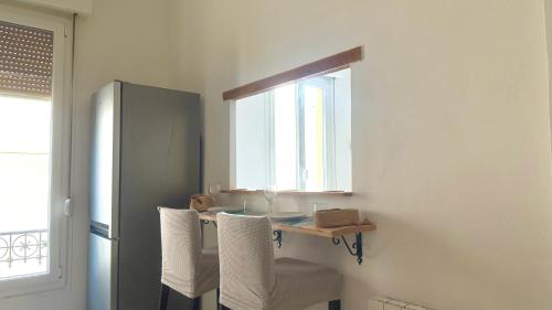 une cuisine avec une table et des chaises ainsi qu'une fenêtre dans l'établissement La Baieta - Typical Nice Apartment, à Nice