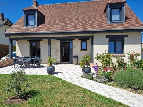 a house with a patio with a table and chairs at Chambre chez l habitant à 10 mn de aéroport 