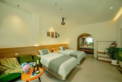 a bedroom with two beds and a couch at Panda's Home Private Hot Spring Cinema Hotel in Taiping