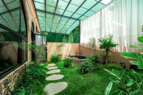 a garden with a glass roof and a walkway at Panda's Home Private Hot Spring Cinema Hotel in Taiping