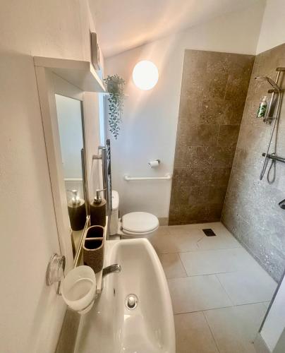 a bathroom with a sink and a toilet and a shower at The Dragonfly Guesthouse - SELF CATERED in Glastonbury