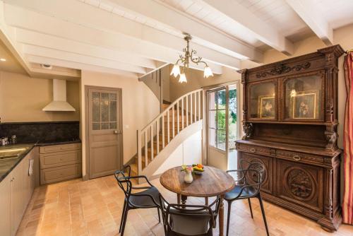 une cuisine avec une table et des chaises ainsi qu'un escalier dans l'établissement Chateau de Lourdes, à Saint-Méloir-des-Ondes