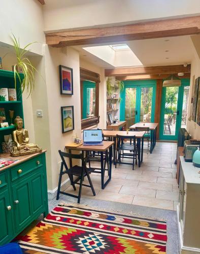 a kitchen with wooden tables and green cabinets and a rug at The Dragonfly Guesthouse - SELF CATERED in Glastonbury