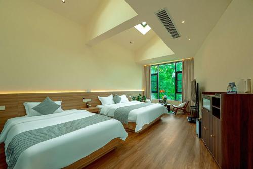 a bedroom with two beds and a television in it at Panda's Home Private Hot Spring Cinema Hotel in Taiping
