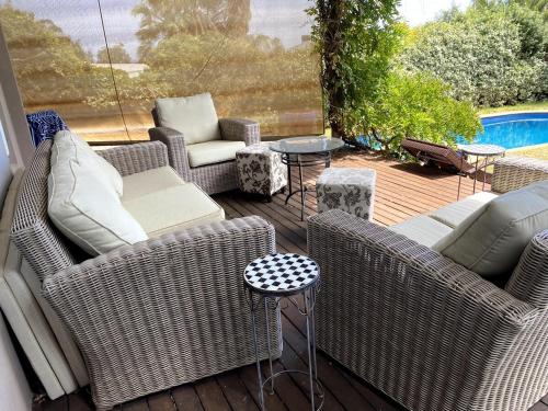 a patio with wicker chairs and tables and a pool at Guest Suite in Marino in Marino