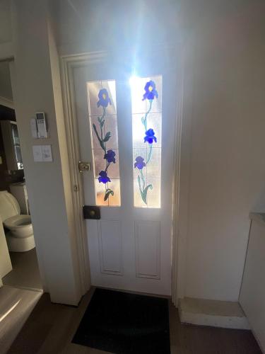 a bathroom door with blue flowers painted on it at Guest Suite in Marino in Marino