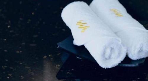two white towels are sitting on a table at Manhatton Hotel Beihai in Beihai