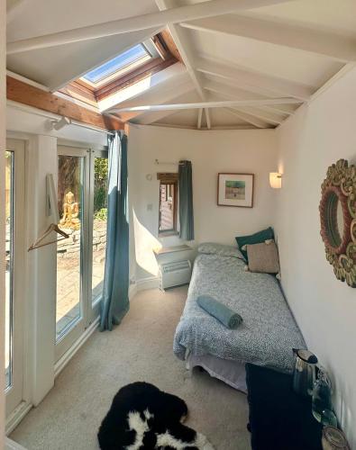 a bedroom with a bed and a window at The Dragonfly Guesthouse - SELF CATERED in Glastonbury