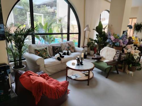 a living room with couches and chairs and a table at Panda's Home Private Hot Spring Cinema Hotel in Taiping