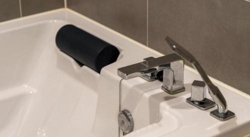 a bathroom sink with a black soap dispenser on it at Seven Motel Ansan in Ansan