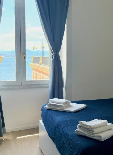 a room with a bed with blue sheets and a window at Izz Home in Naples