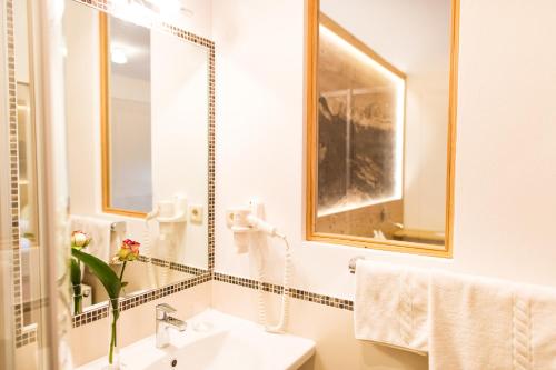 a bathroom with a sink and a mirror at Hotel Wieslhof in Collepietra