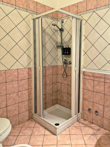 a shower with a glass door in a bathroom at Tobia's House B&B in Giuggianello