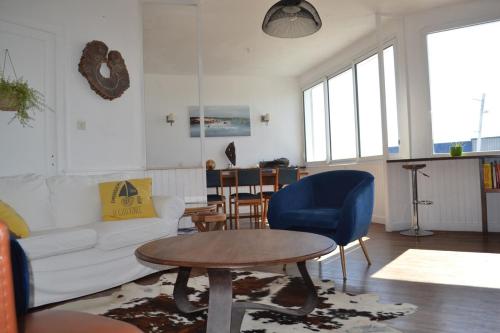 un salon avec un canapé blanc et une table dans l'établissement large apartment with sea view and port of guilvinec, au Guilvinec