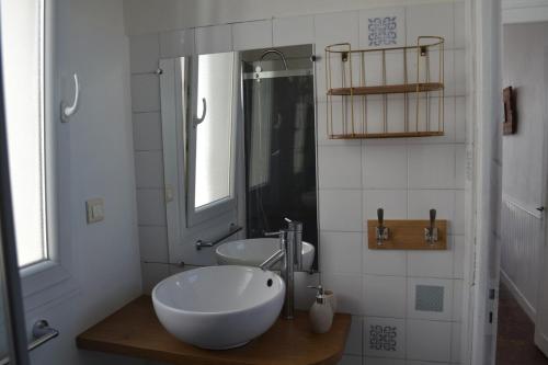 a white bathroom with a sink and a mirror at large apartment with sea view and port of guilvinec in Le Guilvinec