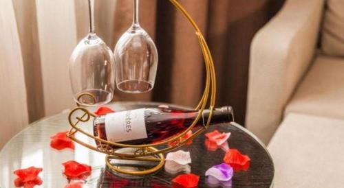 a glass table with a bottle and two wine glasses at Lavande Hotel Zhaoqing government Dinghu Mountain Scenic Spot in Zhaoqing