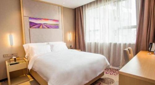 a bedroom with a large white bed and a window at Lavande Hotel Zhaoqing government Dinghu Mountain Scenic Spot in Zhaoqing