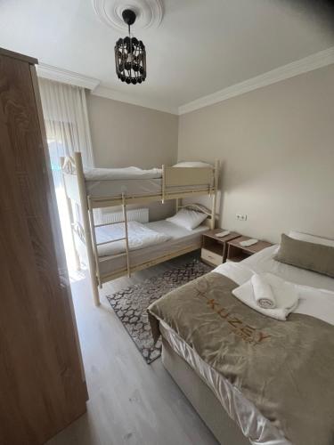 a bedroom with two bunk beds and a chandelier at Karenes KUZEY Pansıyon in Çaykara