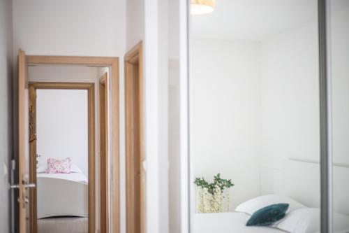 a mirror in a room with a bed and a window at Apartments Villa Flamingo in Makarska