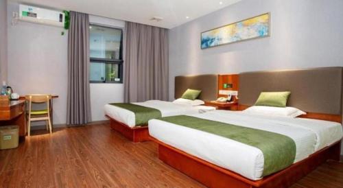 a hotel room with two beds and a desk at Vatica Shanghai Jiading District Anting Metro Station Moyu Road Hotel in Shanghai