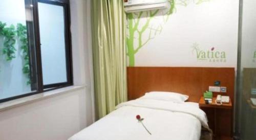 a bedroom with a white bed and a window at Vatica Shanghai Jiading District Anting Metro Station Moyu Road Hotel in Shanghai