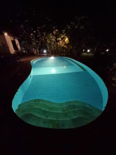 an empty swimming pool at night at Beachfront Villa Jepun Segara in Banjar