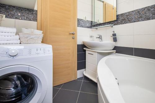 a bathroom with a washing machine and a sink at Apartments Villa Flamingo in Makarska