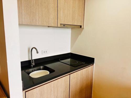 a kitchen with a sink and wooden cabinets at Condo Sea view Beach U40 in Pattaya South
