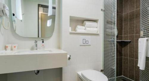 a bathroom with a sink and a toilet and a mirror at ibis xian North Second Ring Weiyang Rd Hotel in Xi'an