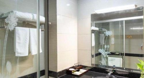 a bathroom with a shower and a sink and a mirror at GreenTree Alliance Hotel Foshan Nanhai District Pingzhou Yuqi Street in Ho-tung