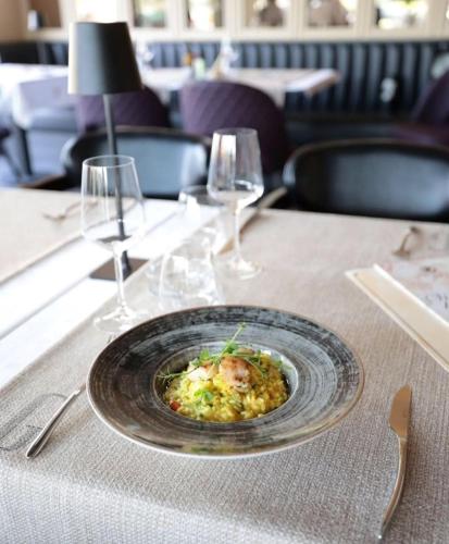 a plate of food on a table with wine glasses at Boutique Hotel St Georgije in Banja Luka