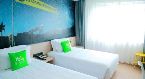 a hotel room with two beds and a window at Ibis Styles Shanghai Qingpu Sports Center Hotel in Shanghai
