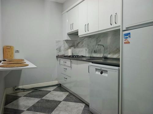 een keuken met witte kasten en een koelkast bij Fethiye central big apartment in Fethiye