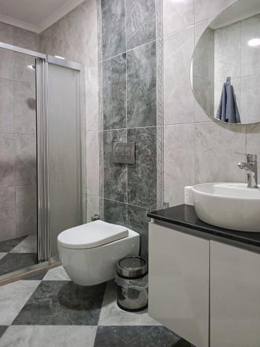 a bathroom with a white toilet and a sink at Fethiye central big apartment in Fethiye