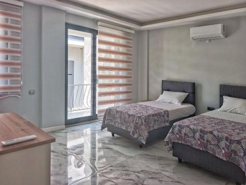 een slaapkamer met twee bedden en een raam bij Fethiye central big apartment in Fethiye