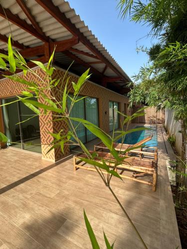 un patio con 2 sedie e una piscina di Pergola House a Assinie