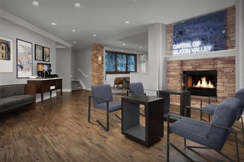 a living room with a fireplace and chairs at Homewood Suites by Hilton San Jose Airport-Silicon Valley in San Jose