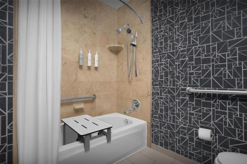 a bathroom with a shower and a white bath tub at Homewood Suites by Hilton San Jose Airport-Silicon Valley in San Jose