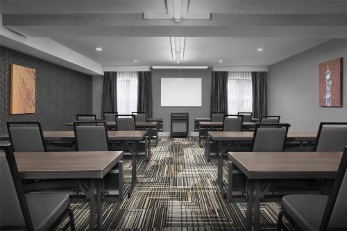 a conference room with tables and chairs and a screen at Homewood Suites by Hilton San Jose Airport-Silicon Valley in San Jose