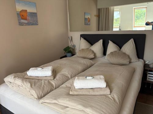 a large bed with two towels on top of it at Strandliebe - Beach Apartment mit Meerblick in Harrislee