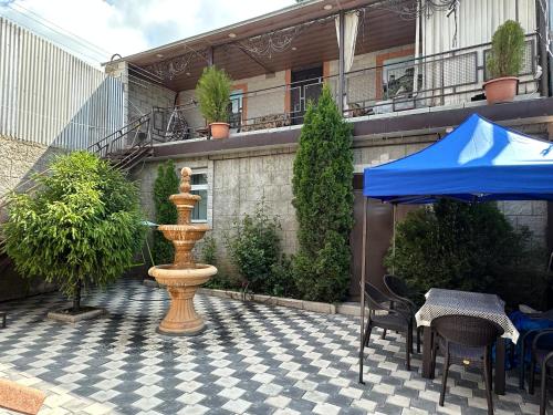 a fountain on a patio with a table and chairs at G&S Guest House in Gyumri