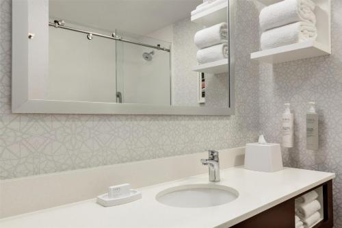 a bathroom with a sink and a mirror and towels at Hampton Inn at Tin Lizzie Gaming Resort in Deadwood