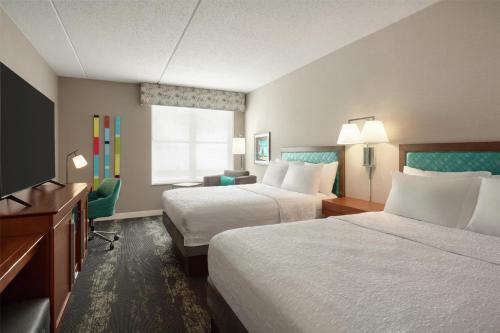 a hotel room with two beds and a flat screen tv at Hampton Inn at Tin Lizzie Gaming Resort in Deadwood